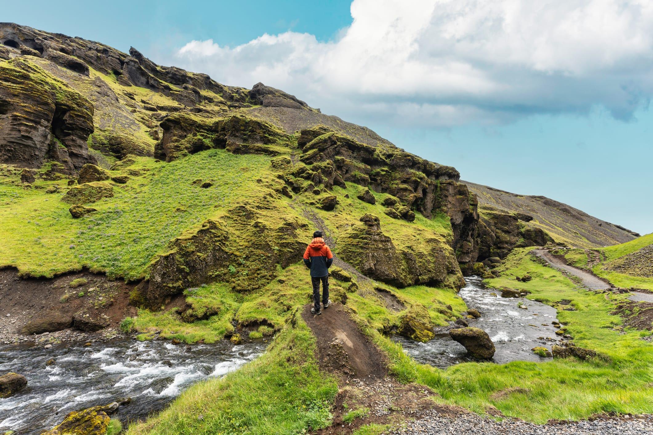 Hiker overlooking stream and rocky landscape
